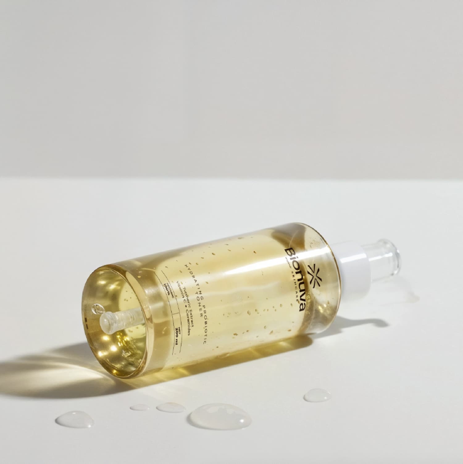 Product photography for Bionuva yellow botanical serum in a transparent bottle with dropper. Designed byannas.com.