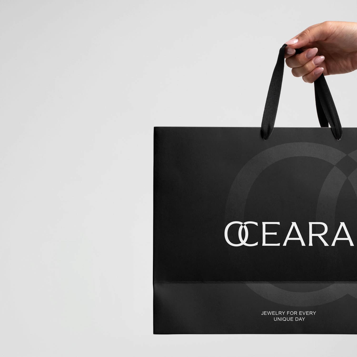 Luxury shopping bag design for OCEARA customizable jewelry brand, featuring minimalist black packaging with logo and tagline. Designed byannas.com.